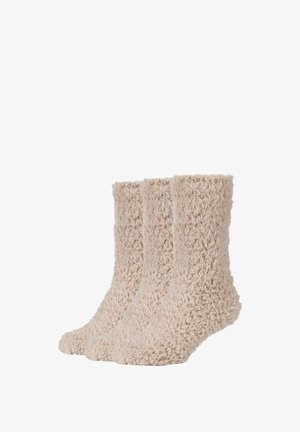 Flauschige beiges Socken aus einem strukturierten, plüschigen Stoff. Drei Paare sind ausgestellt, mit einem hohen Bündchen und einem abgerundeten Zehenbereich.