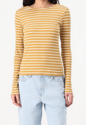 Geel geribd shirt met lange mouwen en witte strepen, ronde halslijn, nauwsluitend ontwerp en lichte rekbaarheid, gecombineerd met lichtblauwe spijkerbroek.