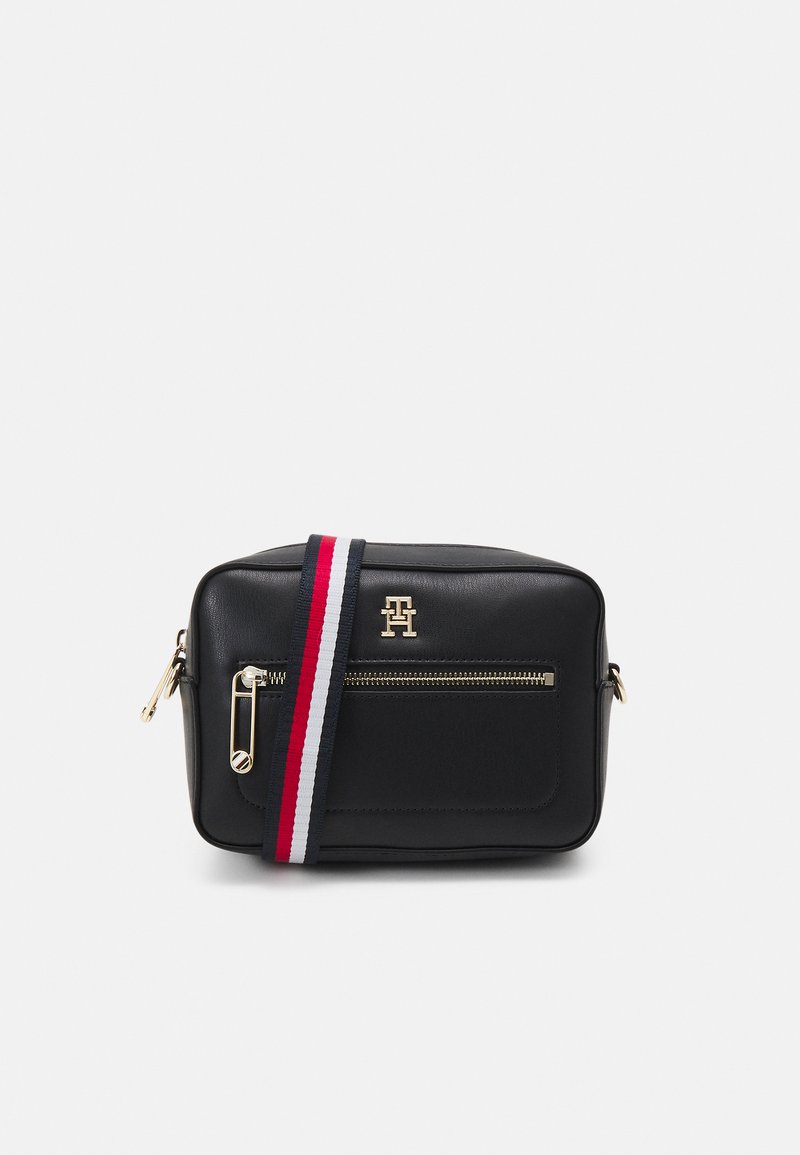 Borsa a tracolla nera in pelle con zipper dorato, dotata di una tasca frontale e di una tracolla regolabile a strisce rossa, bianca e blu.