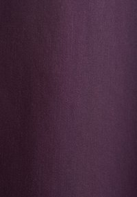 Tessuto strutturato di un profondo colore viola, con sottili linee orizzontali, che presenta una superficie liscia e leggermente lucida.
