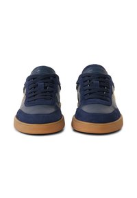 Paire de baskets en cuir et daim bleu marine avec des lacets noirs et des semelles couleur gomme, vues de face sur un fond blanc.