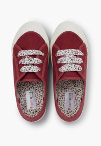 Scarpe di tela rosse con punte in gomma bianca, dotate di rivestimento a motivo floreale e lacci bianchi, progettate in un design a collo basso.