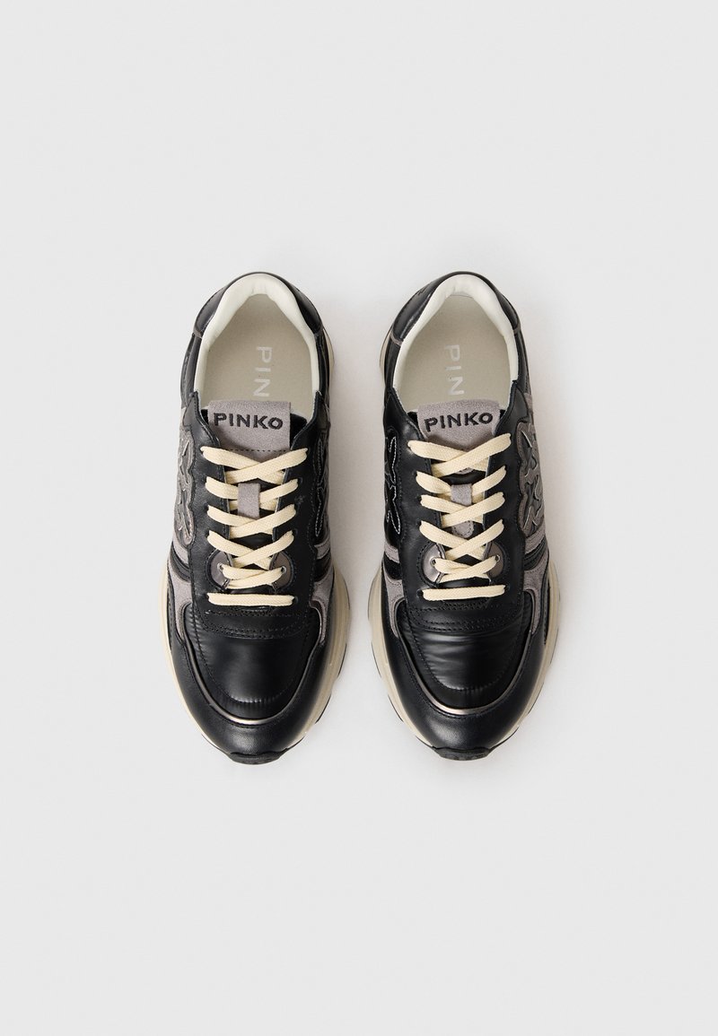 Schwarze Leder- und Wildledersneaker mit beigen Schnürsenkeln, gepolstertem Kragen und grauen Akzenten, strukturierten Oberflächen und Logo auf der Zunge.