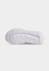 Semelle d'une chaussure de sport blanche montrant un motif de bande de roulement texturé avec des rainures et des crêtes pour l'adhérence sur une surface plane.