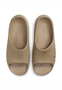 Sandalias beige tipo slip-on con diseño de punta y parte trasera abierta. Textura suave, forma minimalista, con un logo sutil en el lateral.