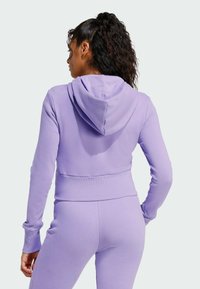 Svetlo fialová skrátená mikina s kapucňou, priliehavý strih a rebrovaný pás, vyrobená z mäkkej zmesi bavlny, predvedená zozadu.