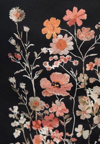 Tessuto nero con stampa floreale che presenta vari fiori in tonalità di rosa, arancione e bianco, accompagnati da dettagliati steli e foglie verdi.