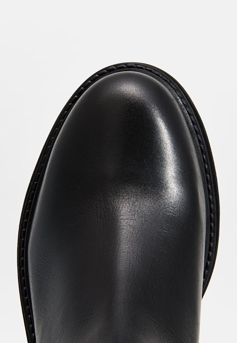 Schwarzer Lederstiefel mit einer glatten, glänzenden Oberfläche, runder Zehenform und kontrastierenden Nähten entlang der Kante. Einfaches Design, ohne Verzierungen.