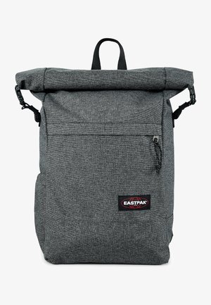 Zaino grigio con chiusura a rotolo realizzato in tessuto testurizzato, dotato di tasca frontale con zipper, spallacci regolabili e maniglia superiore per il trasporto.