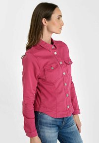 Fitted rozenkleurige spijkerjack met een knoopsluiting aan de voorkant, twee borstzakken en lange mouwen. Glad textuur en klassiek kraagontwerp.