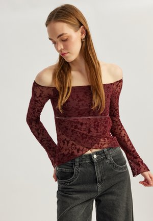 Bordeaux off-shoulder top med lange ærmer, gennemsigtig blomsterlacet stof, lagdelt design og en vandret bånd over taljen.