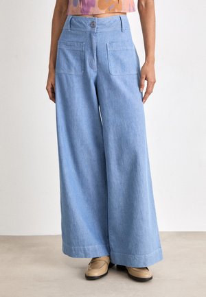 Light blue, wide-leg trousers made of soft denim. Features a button closure, two back pockets, and a relaxed fit with a hemmed edge.
