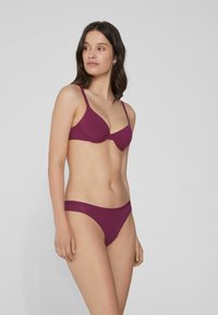 Bralette mauve et string assorti. Tissu doux et extensible avec une texture lisse. Le bralette comporte des bretelles réglables et des bonnets moulés.