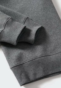 Grå sweatshirt med blød tekstur, ribbede manchetter og kant. Stoffet er glat med en ensartet farve, der fremhæver et enkelt design.