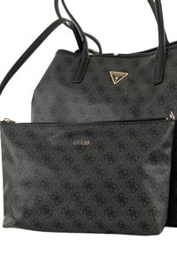 La borsa Guess nera presenta un esterno testurizzato con un sottile motivo del logo, hardware in tono oro e una pochette rimovibile con zip.