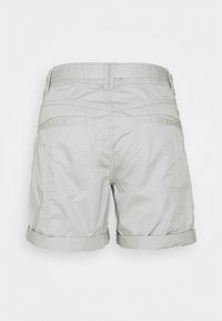 Pantalones cortos gris claro hechos de tejido texturizado, con dobladillos enrollados, dos bolsillos traseros y una cinturilla estándar con detalles de costura.
