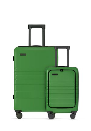 Two green luggage pieces, one large and one small, with a smooth hard shell, horizontal ridges, telescopic handles, and rolling wheels.