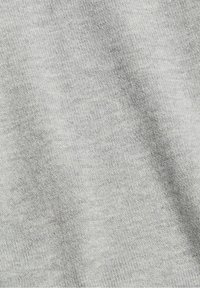 Jasnoszary materiał o gładkiej, miękkiej fakturze, z delikatnym wzorem dzianym, miękko opadający z lekkim połyskiem.