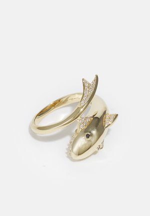 Gold ring shaped like a fish with a smooth body and textured fin, adorned with small clear stones and an eye detail.