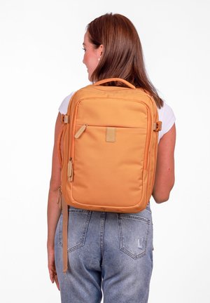 Orange fabric backpack with a spacious main compartment, front zip pocket, and adjustable straps. Smooth texture with a minimalist design.