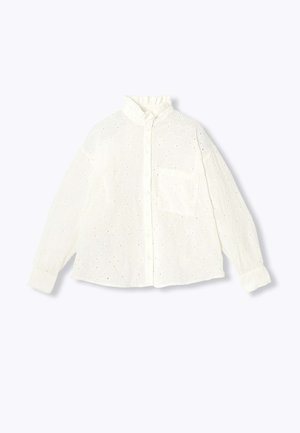 Chemise blanche brodée avec un col mao, une fermeture à boutons sur le devant, des manches longues et une poche poitrine. Présente des motifs ajourés sur toute la surface.