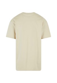 Cremefarvet t-shirt med kort ærme, rund hals og en blød, glat tekstur. Ingen synlige mærker eller mønstre på ryggen.