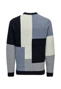 Achteraanzicht van een gebreid vest met een geometrisch blokpatroon in zwart, wit, grijs en textuur grijze mouwen.