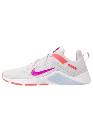 Baskets Nike gris clair avec un swoosh rose vif, des accents corail, une semelle blanche et une tige en mesh respirant.