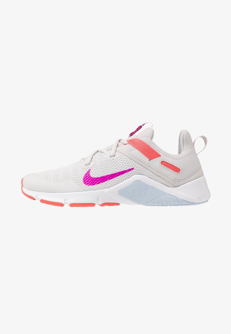 Baskets Nike gris clair avec un swoosh rose vif, des accents corail, une semelle blanche et une tige en mesh respirant.