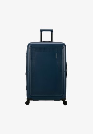 Valigia rigida di colore blu scuro, con motivi testurizzati diagonali, manico retrattile e quattro ruote girevoli per la mobilità.