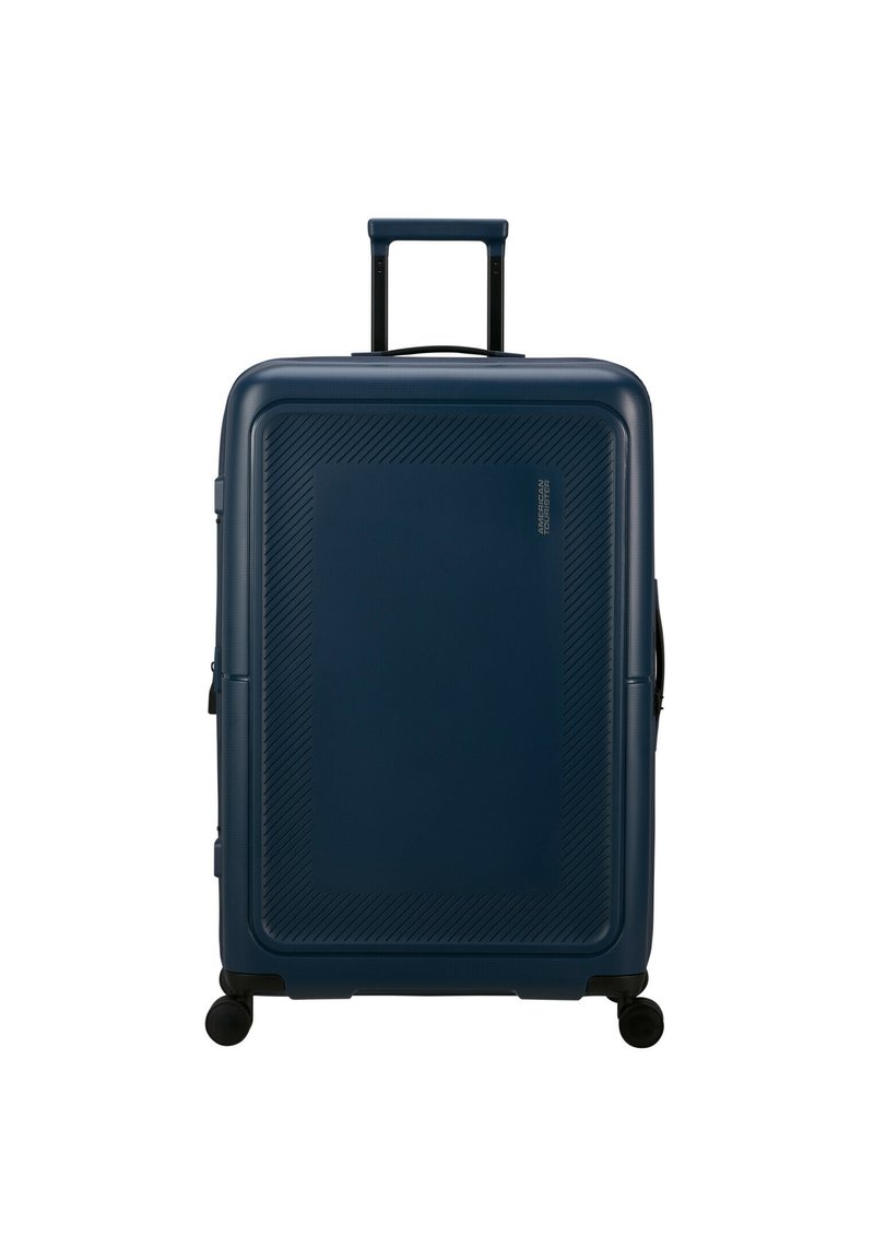 Valigia rigida di colore blu scuro, con motivi testurizzati diagonali, manico retrattile e quattro ruote girevoli per la mobilità.