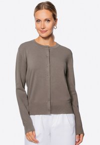 Knappt knit Cardigan in Taupe, aus einem weichen, strukturierten Stoff hergestellt. Verfügt über gerippte Bündchen und Saum sowie dezente Details an den Ärmeln.