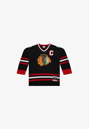 Schwarzes Eishockey-Trikot mit roten und weißen Streifen, das ein Logo eines amerikanischen Ureinwohner-Kopfs und ein rotes "C" Captain-Patch auf der Brust zeigt.