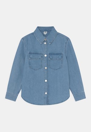 Lyseblå denimskjorte med lange ærmer, forreste knaplukning og to brystlommer med klapper mod hvid baggrund.