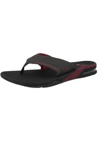 Black sandals with a red accent; featuring a textured upper, toe post design, cushioned sole, and a visible air chamber in the heel.