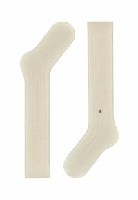 Calze beige a costine con una texture liscia, dotate di un'area della punta accentuata e di un piccolo bottone decorativo sul lato.
