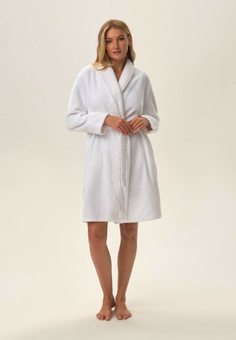 Biała szata z miękkiego materiału, z kołnierzem szalowym i teksturowanymi mankietami, związywana w pasie i o długości do kolan.