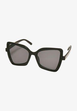 Occhiali da sole oversized neri con forma geometrica, montatura spessa e lenti scure. Presentano dettagli sottili agli angoli della montatura.