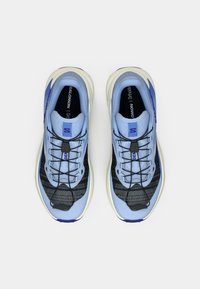 Ανοιχτό μπλε αθλητικά παπούτσια με μαύρη επάνω πλευρά από πλέγμα, λευκή σόλα και μωβ λεπτομέρειες. Διαθέτουν κορδόνια και επενδυμένο γιακά.