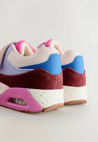 Casualne sneakersy z bordo zamszu, niebieskimi skórzanymi akcentami na pięcie, różowym siateczkowym wykończeniem, białymi, nakrapianymi środkami oraz różowymi, teksturowanymi podeszwami z poduszkami powietrznymi.