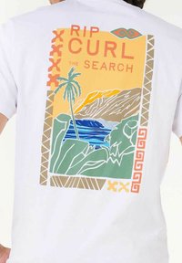 Hvid bomulds t-shirt med et farverigt grafik, der viser palmer, bølger og bjerge i orange, grøn og blå med dekorative kanter.