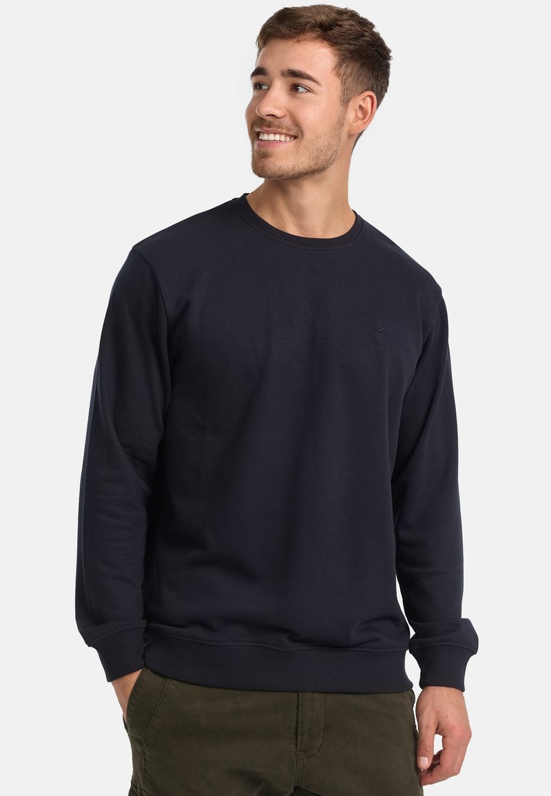 Marineblauwe crewneck sweatshirt van zacht materiaal, met ribgebreide boorden en onderkant, en een subtiele logo-detail op de borst.