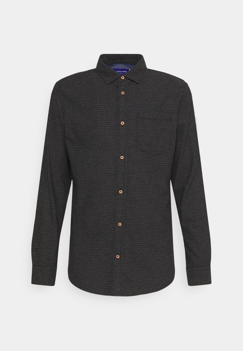 Chemise noire à manches longues boutonnée, avec une texture subtilement pointillée et des boutons marron, dotée d’un col plié et d’une poche poitrine unique.