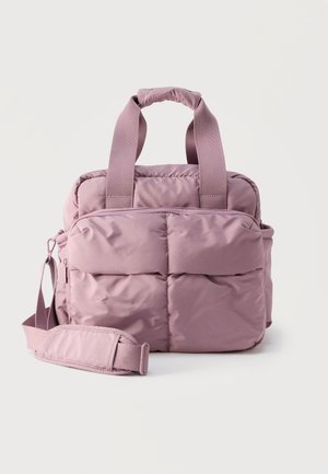 Sac rectangulaire matelassé mauve doux avec double poignées et une bandoulière réglable sur fond uni.