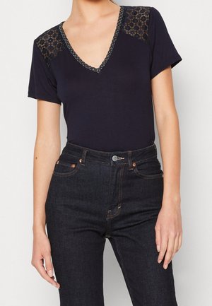 Granatowy bodysuit z krótkim rękawem i głębokim dekoltem w kształcie litery V, z koronkowymi akcentami na ramionach oraz teksturowanym wykończeniem wzdłuż dekoltu.