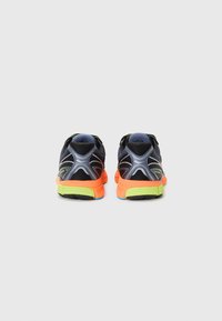 Black athletic shoes with a breathable mesh upper, contrasting orange and green sole, and reflective accents on a streamlined design.