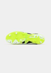 Crampon de football noir et jaune fluo avec une semelle texturée comportant plusieurs crampons et une sangle de soutien au milieu du pied.