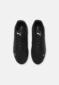 Mustat urheilukengät, joissa on sileä kangas päällinen, valkoiset logo-yksityiskohdat, pyöreä kärki, nauhakiristys ja hengittävyysaukkoja.