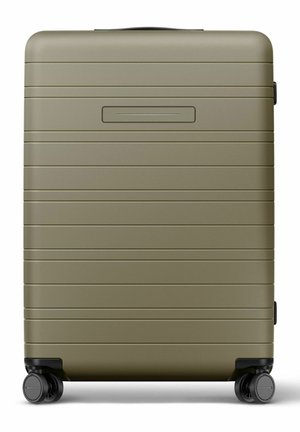 Valise rigide vert olive avec des rainures horizontales, quatre roues pivotantes noires et une poignée supérieure.