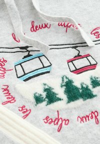 Gray fabric with embroidered ski gondolas in blue and red, surrounded by green trees and text in pink. Soft texture with a cozy design.